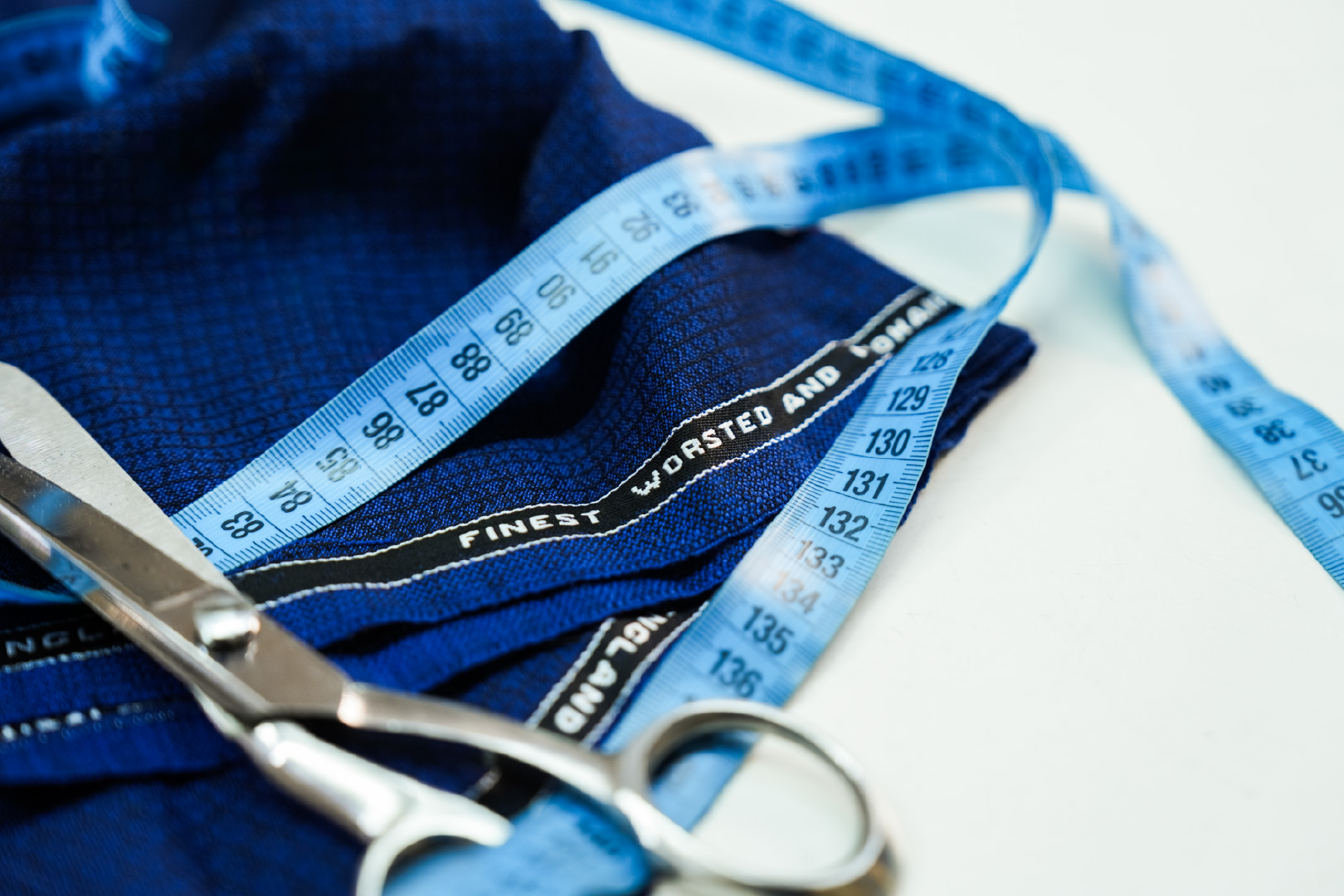 Navy worsted wool with its Finest Worsted and Woollens selvedge, tailor's shears and a tape measure